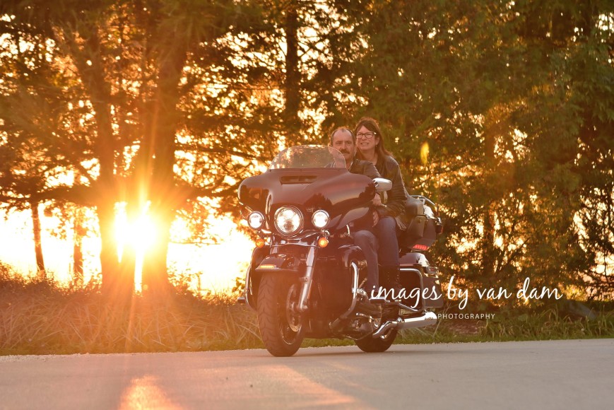couple rides harley davidson at sunset