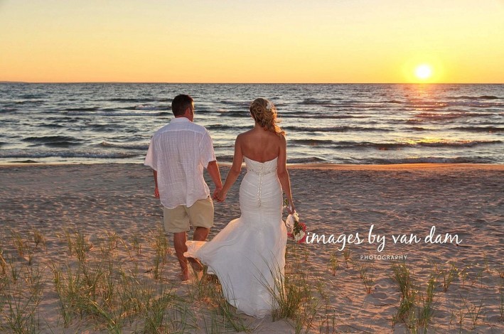 barrie photographer wedding couple walking hand in hand towards epic sunset at wasaga beach wedding