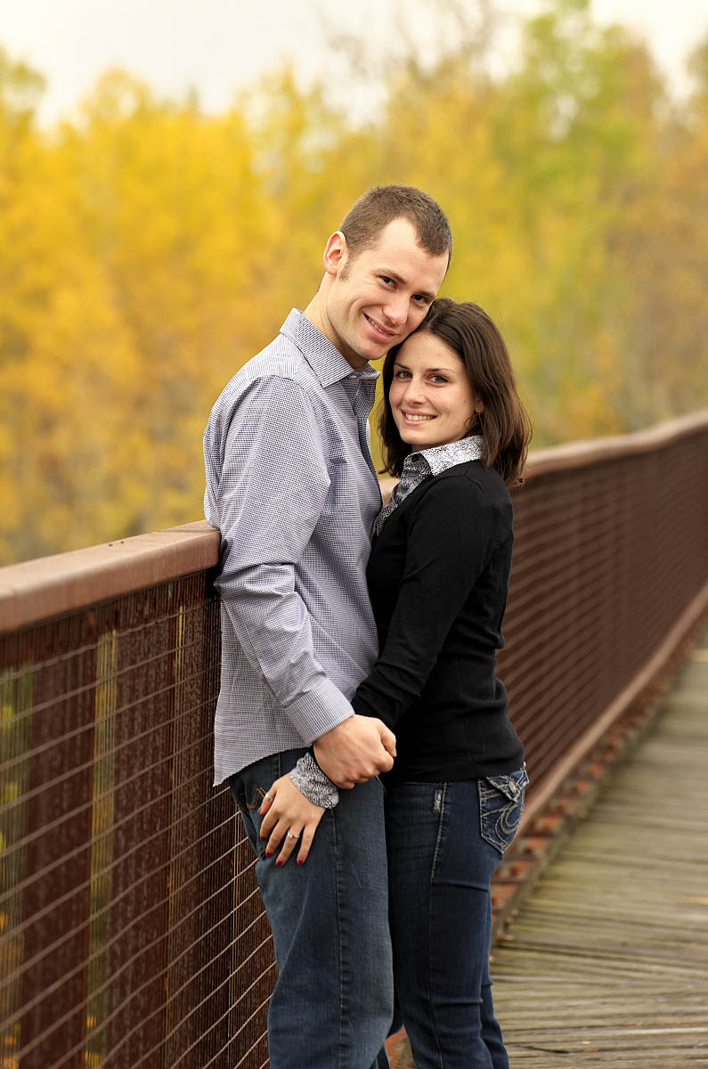 Young couple on trestle bridge at Orange corners engagement session near Omemee, Lindsay, and Peterborough