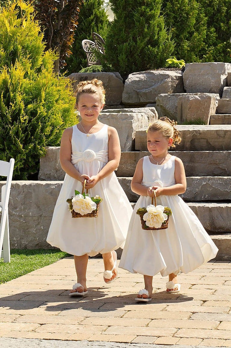 flower girls walk down the aisle together