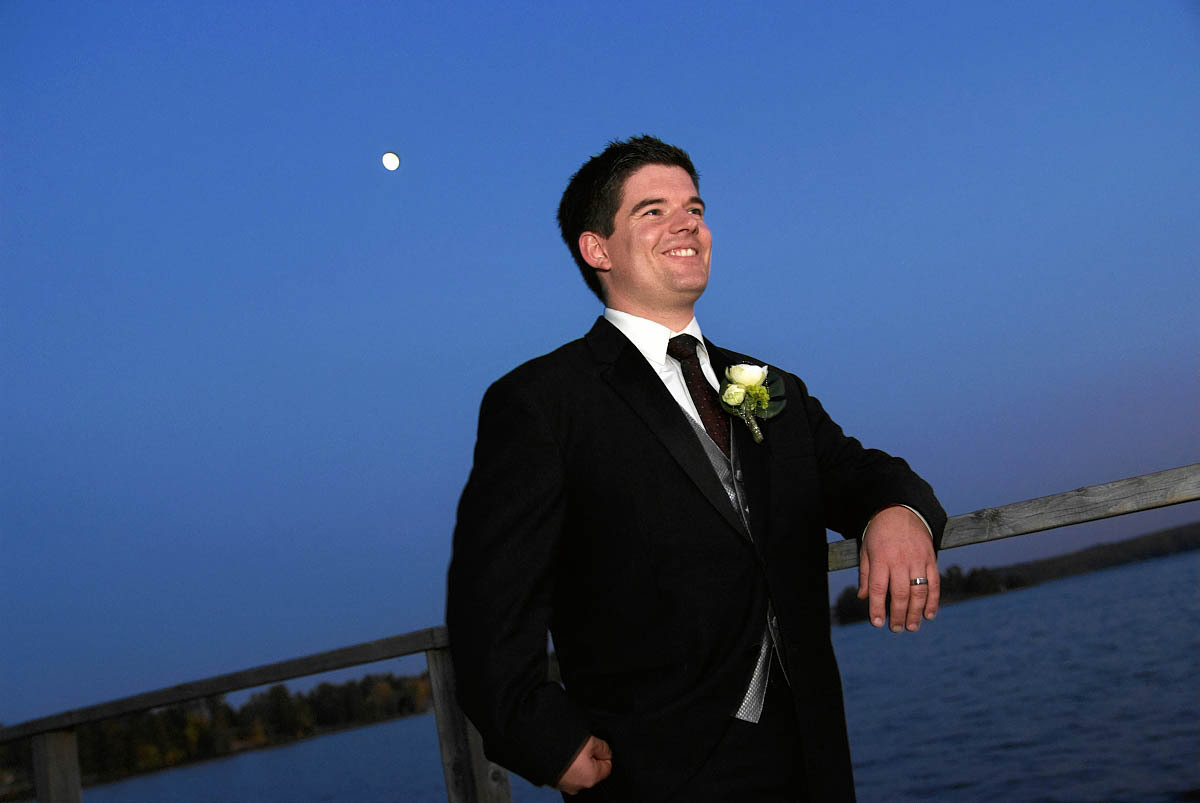 groom on dock at night at viamede resort wedding