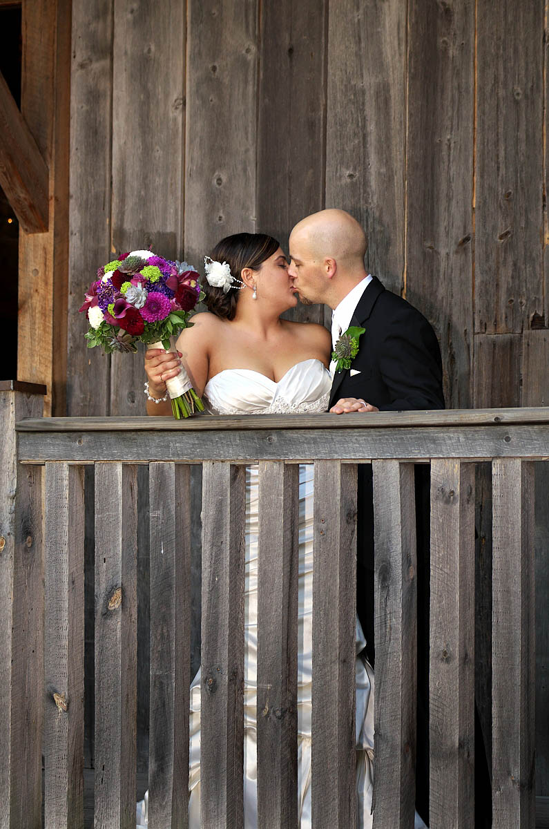 wedding kiss on barn balcony