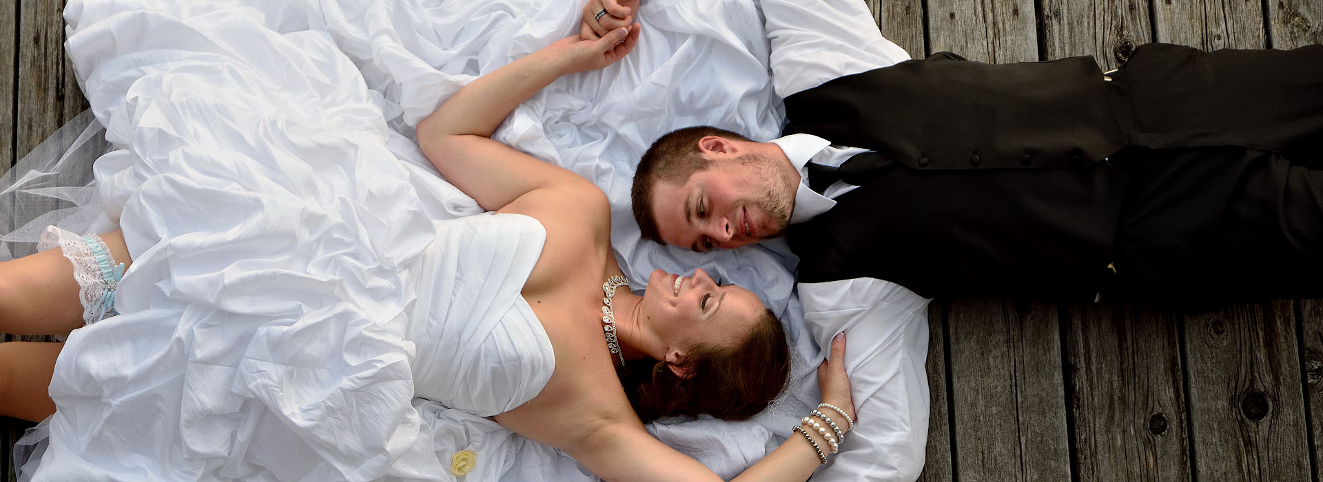 bride and groom lying on dock at discovery harbour in penetanguishene ontario