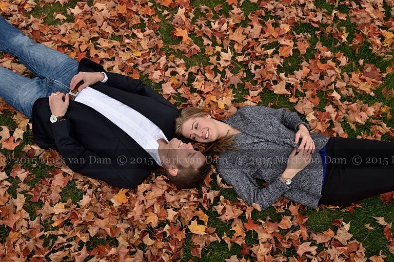 Couple lying head to head in fall leaves