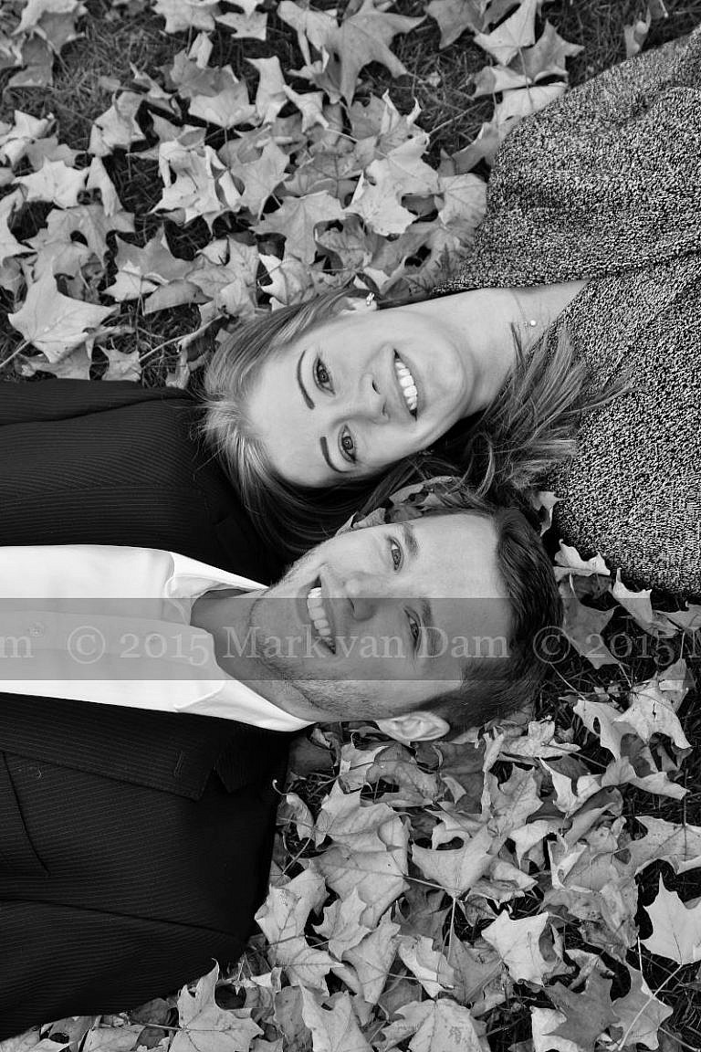 couple lying with heads beside eachother in fall leaves at Orillia photography session