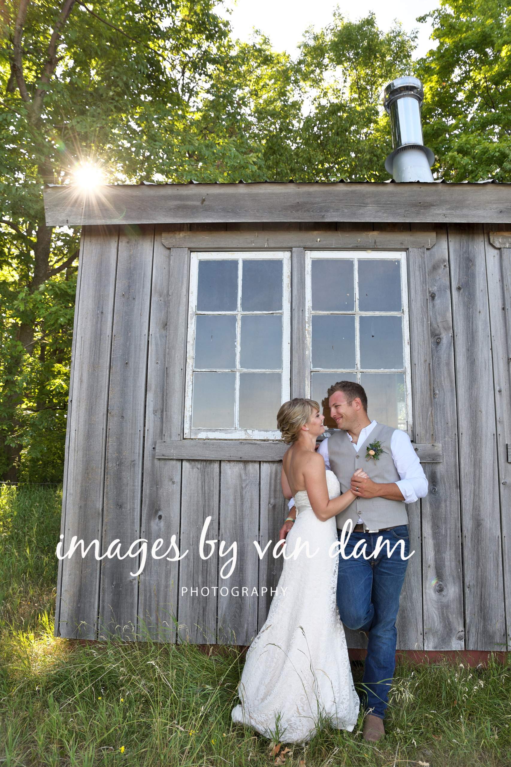 wedding couple embraces by the shed in the back field at a farm wedding in Kawartha Lakes