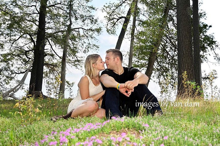 Couple kisses in meadow of flowers at country engagement session in kawartha lakes
