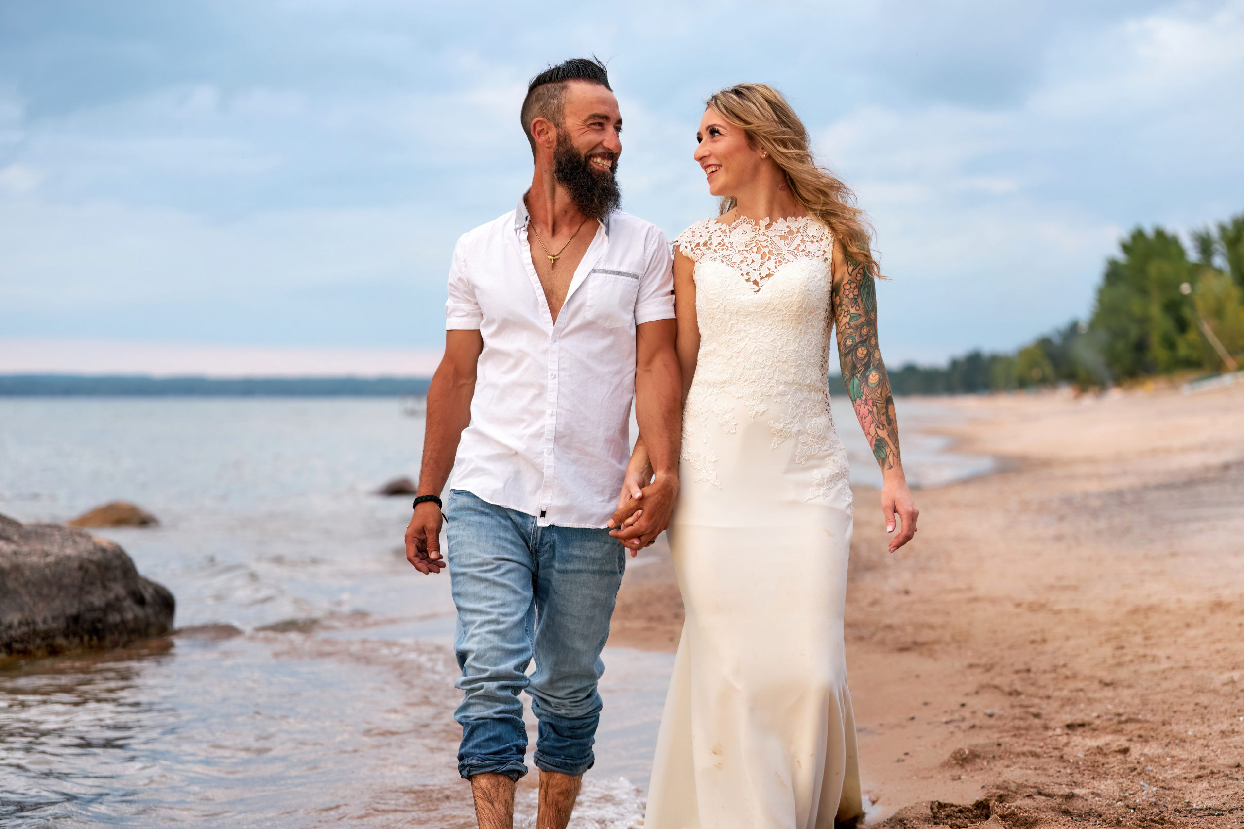 Couple Holding Hands and in Love Walking Along Beach at Trash the Dress Session