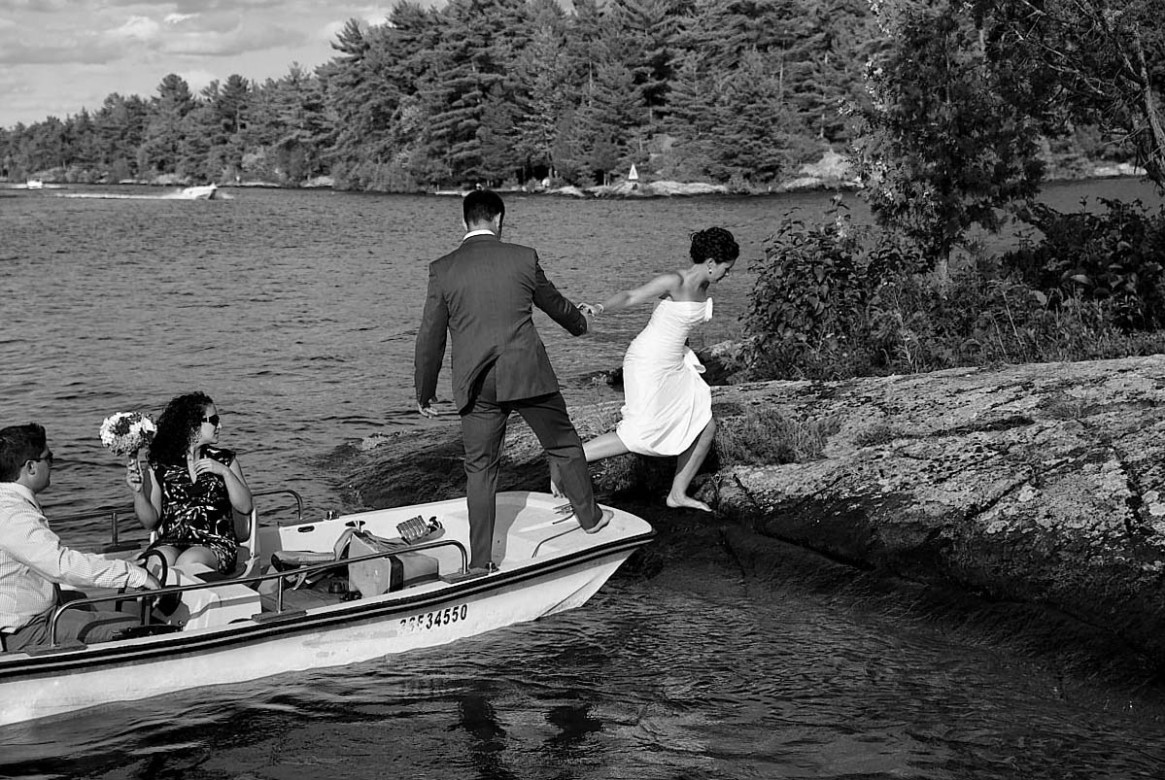 bride climbs onto island from boat
