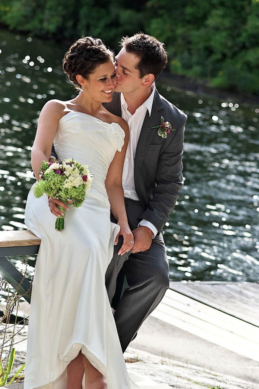 groom kisses brides cheek on stoney lake