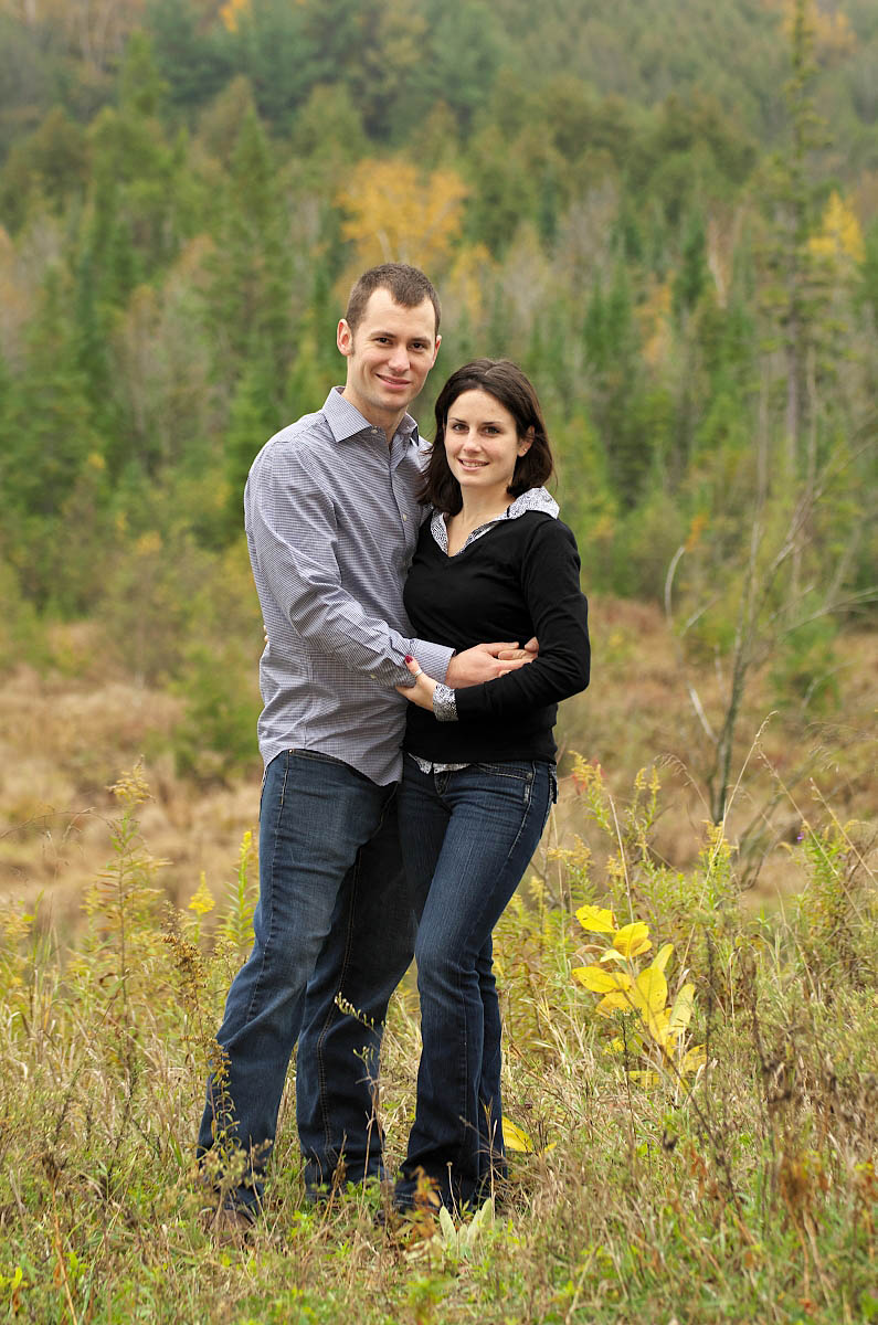 Couple embraces above Orange Corners Valley during Kawartha lakes engagement session