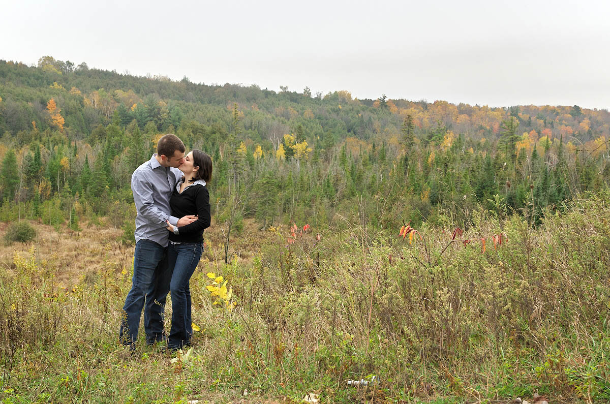 Young couple kissing at valley overlook in Orange Corners, Ontario