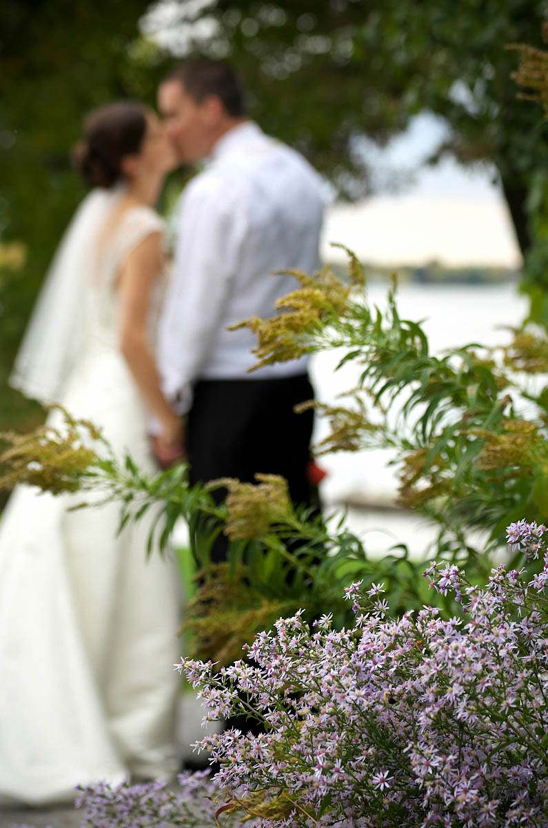 Bride and groom with wildflowers and lake at Eganridge wedding
