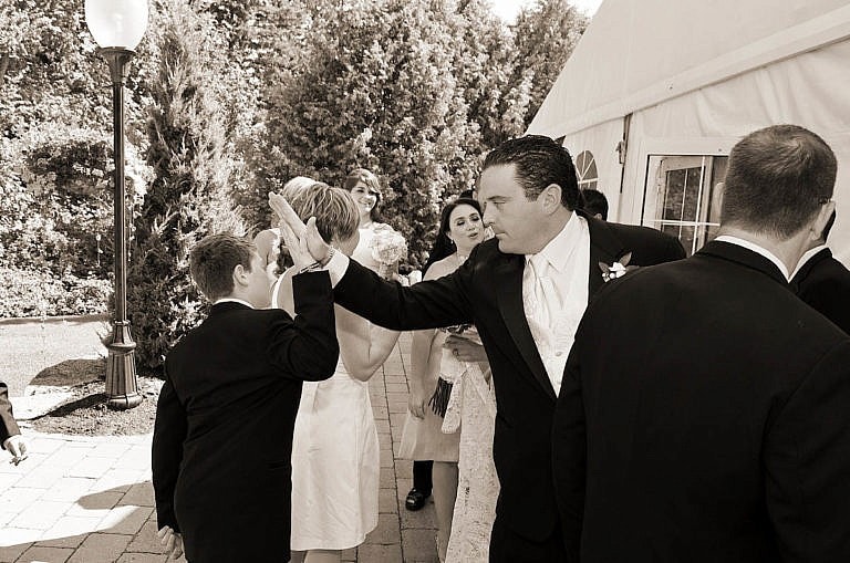 groom gives young guest a high five after wedding ceremony