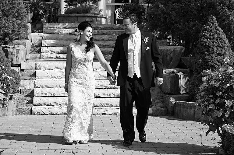 bride and groom strolling in garden at royal ambassador wedding