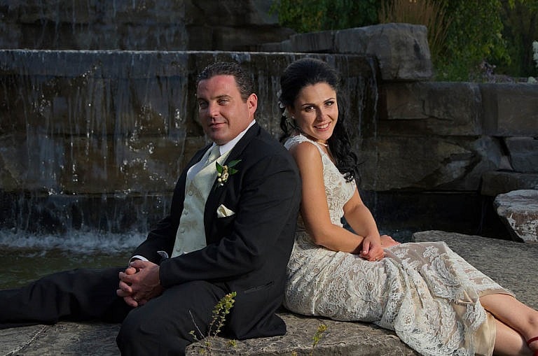 bride and groom by garden waterfall at Royal Ambassador wedding