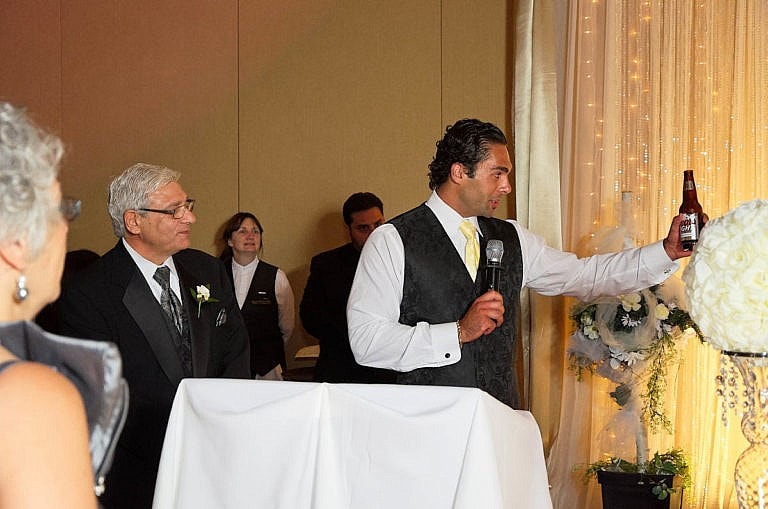 groomsman makes a toast at wedding reception