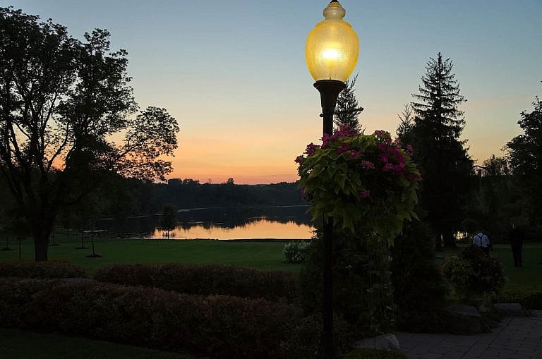 Lamp post, garden, and pond at dusk at Royal Ambassador