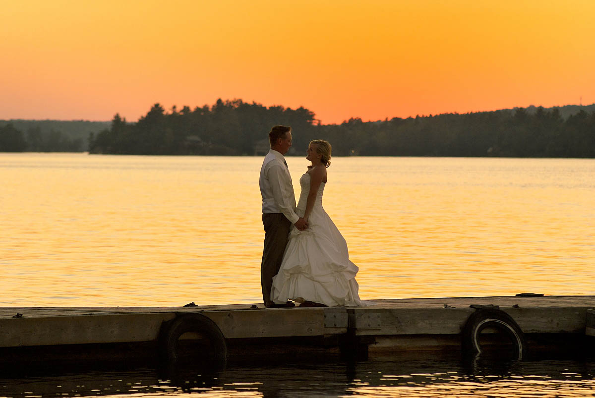 wedding couple at sunset on dock at irwin inn on stoney lake