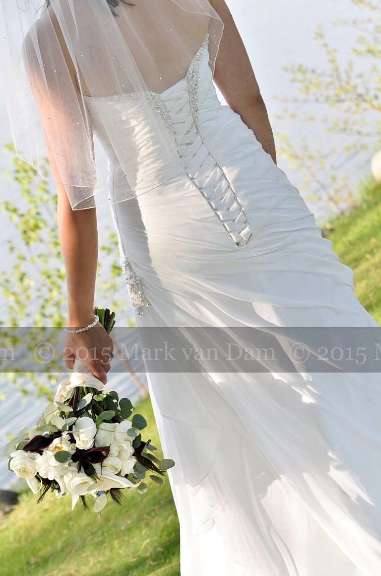 Detail of back of dress and bouquet of Beautiful bride by Georgian Bay at Living Waters Resort at The Bear Estate at Cranberry Resort