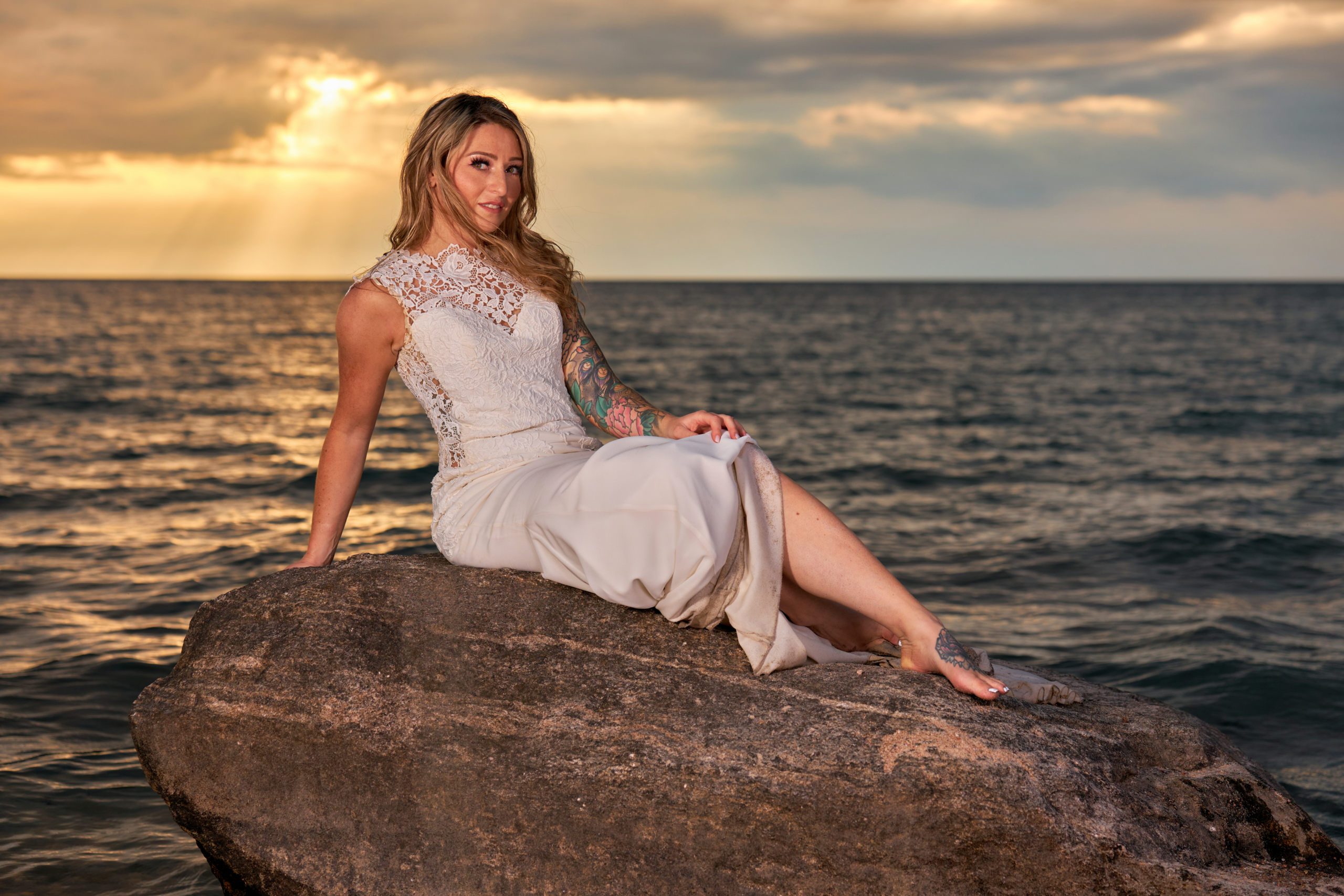 Bride Sitting on Rock in Georgian Bay Beach at Sunset During Trash the Dress Session