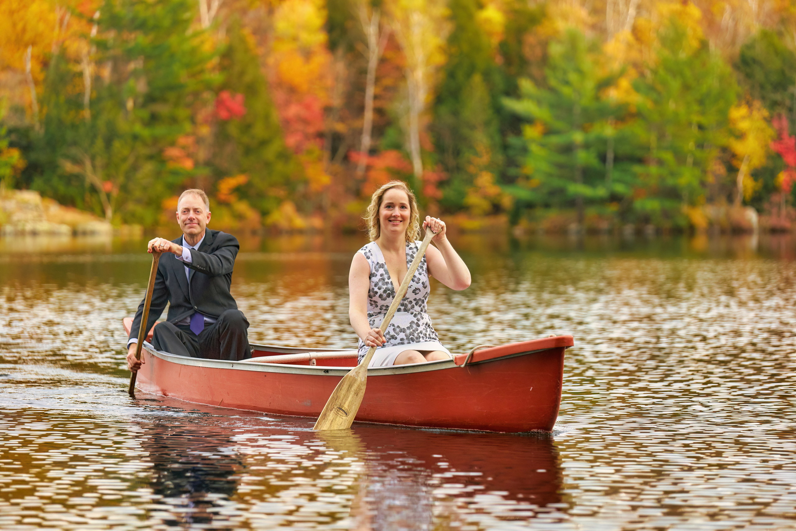 Bride and Groom Canoeing with brilliant fall colours by Cherry Island at Muskoka Wedding