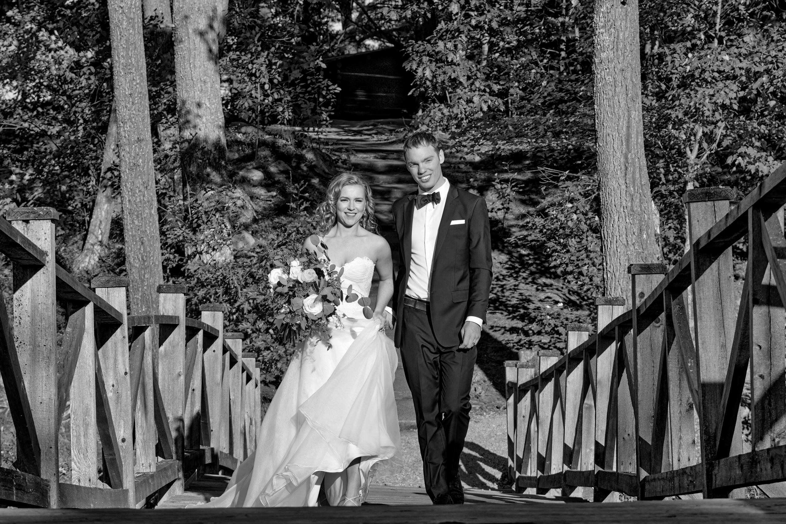 Bride and Groom Walk Across Island Bridge at French River Wedding at The Lodge at Pine Cove